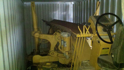Caterpillar 140G grader is loaded onto cube container for international shipment by Export Logistics & Shipping, Inc.